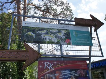 historische Anzeigetafel mit Leuchtreklame weist den Weg zum 200 m entfernten Reichelsdorfer Keller. Auf der Werbefläche ein Plakat der Entwicklungsgesellschaft.