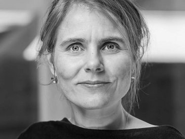 Portraitfoto der dänischen Architektin Mikala Samsøe, elegante Frau im mittleren Alter, freundlicher wacher Gesichtsausdruck, lange Haare, Ohrstecker