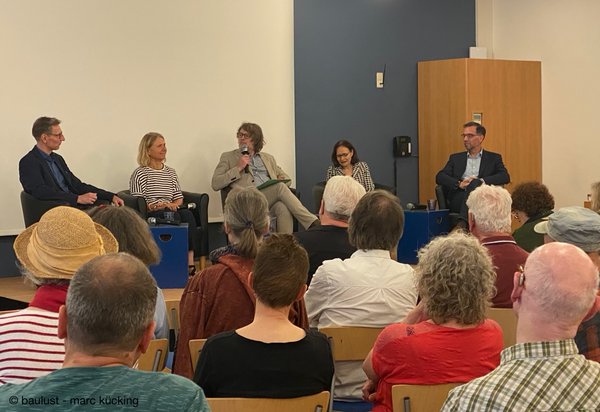 Podiumsdiskussion: Referent, Gäste und Moderator auf der Bühne